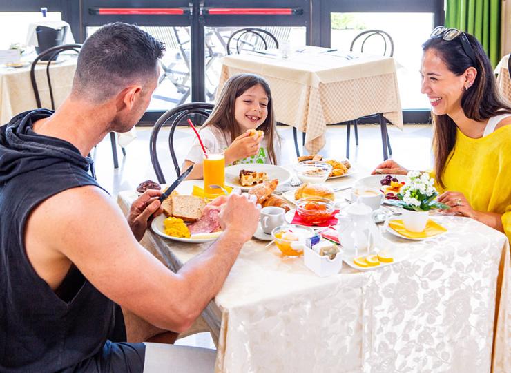 Glückliche Familie beim Frühstück in einem hellen Restaurant.