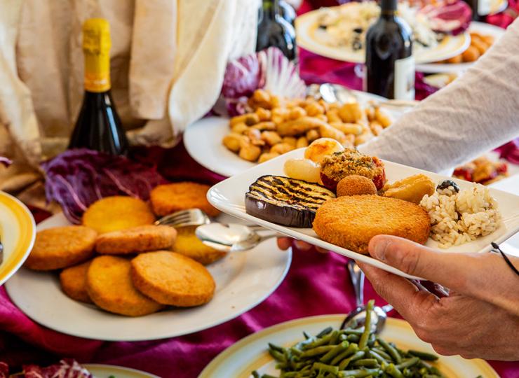 Buffet mit verschiedenen Gerichten und Wein auf gedecktem Tisch.