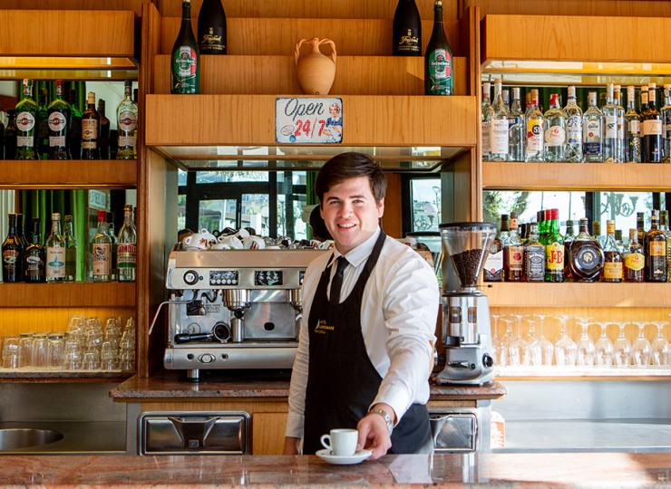 Barista serviert Kaffee in einer gut ausgestatteten Bar.