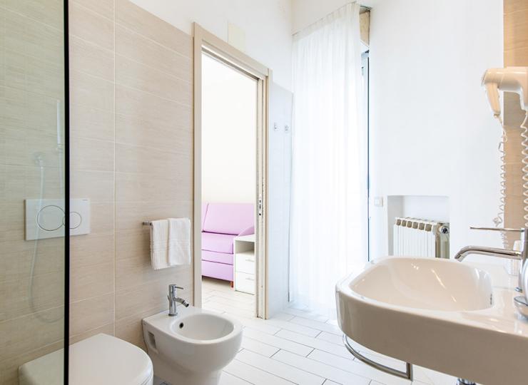 Modernes Badezimmer mit Bidet und Dusche, Blick ins Schlafzimmer.